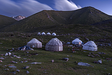 Yurts are beautifully arranged in the mountains around Kol-Ukok lake at dusk, highlighting the cultural nomadic lifestyle, Kyrgyzstan, Central Asia, Asia