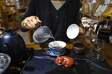 Tea ceremony - tea poured in a glass by a woman