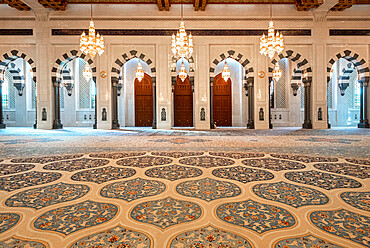 Male praying room of the Sultan Qaboos Mosque with decorated carpet and many arches, Muscat, Oman, Middle East