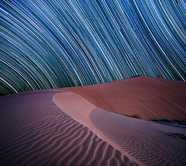 Equatorial star trail above sand dunes in the Rub al Khali desert, Oman, Middle East