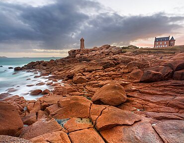 Sunrise long exposure at Ploumanac???h lighthouse and a house over the pink granite coast in Brittany. France