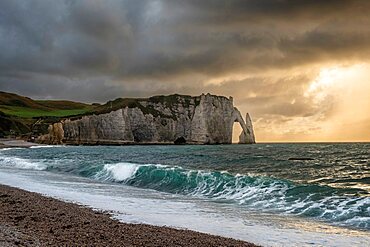 Sunset from the beach of Etretat, over the sea, the cliffs and the natural arch, Normandy, France