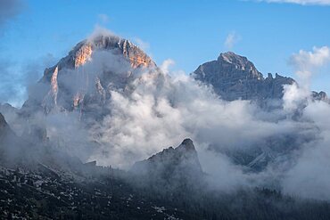 Tofane at sunrise with low clouds and a blue sky, Dolomites, Italy