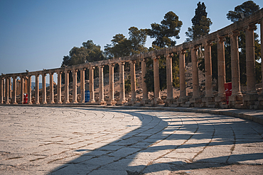 Jerash forum in the early morning with a long colonnade projecting shadows, Jerash, Jordan, Middle East