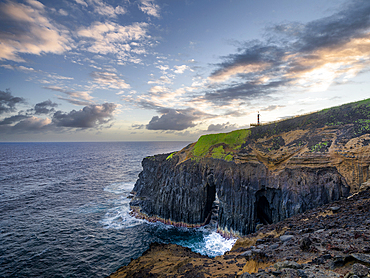 Cliff above the ocean, with a natural arch and small lighthouse, Farolim dos Fenais da Ajuda, Sao Miguel island, Azores islands, Portugal, Atlantic Ocean, Europe