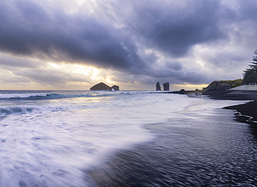 Long exposure of waves on the black sandy beach of Mosteiros with a cloudy sunset and the sea stacks in the background, Mosteiros, Sao Miguel Island, Azores Islands, Portugal, Atlantic, Europe