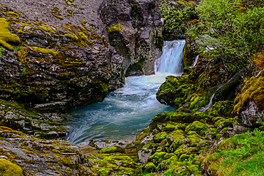 Water forms waterfalls and ponds as it snakes its way down a mountain at Briksdal glacier, Stryn, Vestland, Norway, Scandinavia, Europe