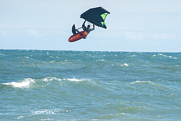 Pro surfer James Jenkins flies above the Atlantic Ocean on his wing surfer at Nags Head, North Carolina, United States of America, North America