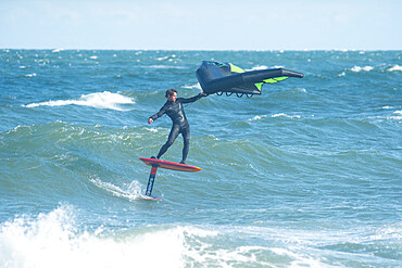 Pro surfer James Jenkins foil surfs a wave on his wing surfer in the Atlantic Ocean at Nags Head, North Carolina, United States of America, North America