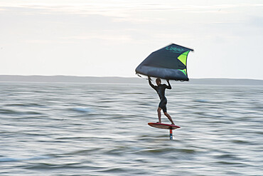 Pro surfer James Jenkins flies above the Atlantic Ocean on his wing surfer at Nags Head, North Carolina, United States of America, North America