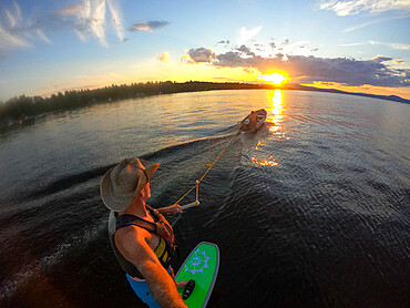 Photographer Skip Brown foils behind a small boat at sunset on Sebago Lake, Maine, United States of America, North America