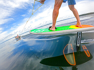 Photographer Skip Brown rides his hydrofoil behind a small boat at on Sebago Lake, Maine, United States of America, North America