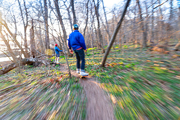 Brothers ride their One-Wheels on a single track mountain biking trail next to the Potomac River, Bethesda, Maryland, United States of America, North America