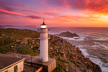 Aerial sea landscape view of Cape Tourinan Lighthouse at sunset with pink clouds, Galicia, Spain, Europe