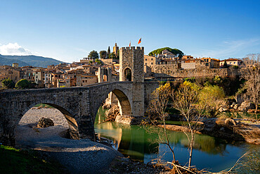 Besalu historic medieval city with Catalonia flags on the stone bridge tower crossing El Fluvia river, Besalu, Catalonia, Spain, Europe