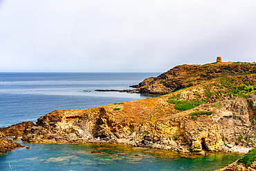 Portu su Gaurru wild beach in the coast of Sardinia with historic tower on the top of the cliff, Sardinia, Italy, Mediterranean, Europe