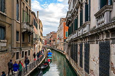 Venice street full of tourists beside a canal between colorful houses and boats, Venice, UNESCO World Heritage Site, Veneto, Italy, Europe