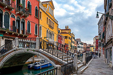 Venice street with colorful houses and a bridge over the canal with boats, Venice, UNESCO World Heritage Site, Veneto, Italy, Europe