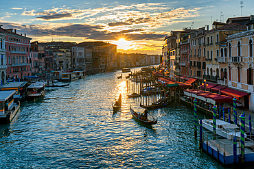 View from Rialto Bridge with colorful houses and the Grand Canal with traditional gondola boats at sunset, Venice, UNESCO World Heritage Site, Veneto, Italy, Europe