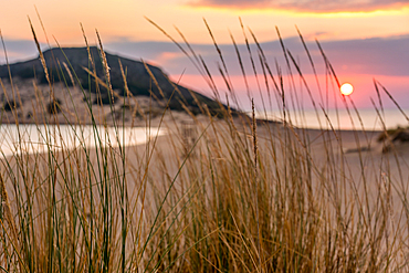 Sun setting down at the sea on a wild natural beach, in Greece