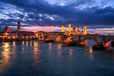 Basilica del Pilar Cathedral and Salvador Cathedral with stone bridge crossing Ebro River at night, Zaragoza, Aragon, Spain, Europe