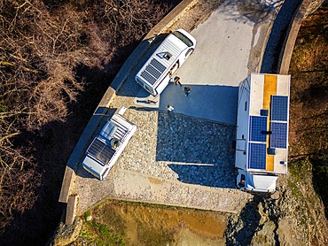 Drone aerial view of camper vans with solar panels on the roof, parked on a wild spot on the mountains in autumn, Kalabaka, Greece