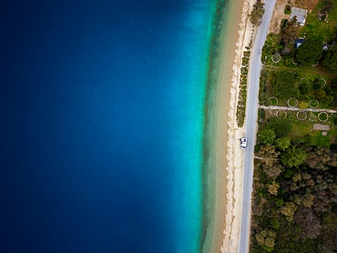 Camper van drone top aerial view parked on a wild beach in Porto Koufo, Greece