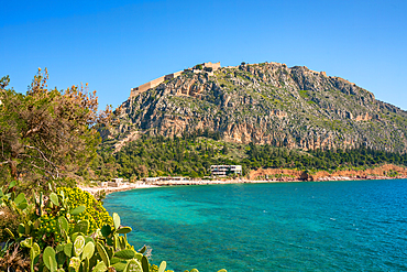 Arvanitias beach in historic city of Nafplion with Palamidi fortress on top of the mountain in Greece