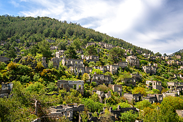Kayakoy greek ghost town with abandoned houses in the mountains full of vegetations in Fethiye, Turkey