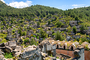 Kayakoy greek ghost town church and abandoned houses in the mountains full of vegetations in Fethiye, Turkey