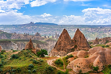 Red and rose valley landscape with colorful rock formations with Ortahisar city on the background in Cappadocia, Turkey