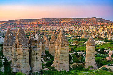Rocket valley rock formations with Red and Rose valley on the background in Cappadocia, Turkey at sunset