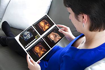 6 months pregnant woman, holding her second term scan.