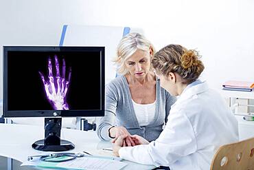 Doctor examining patient's hand.