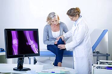 Doctor examining patient's knee.