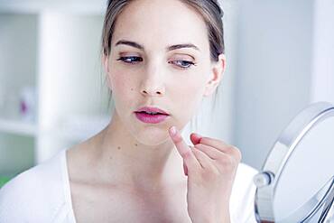 Woman looking at herself in the mirror.