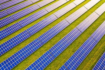 Aerial view looking down onto commercial solar panels at sunrise in the English countryside