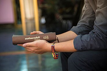 A man who is sitting in the church with his holy bible.