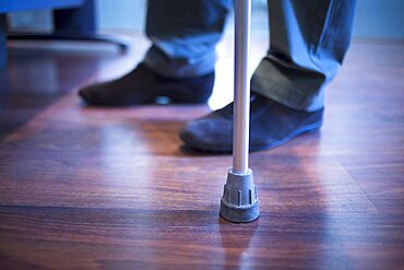 Man walking with crutch in hospital clinic photo.