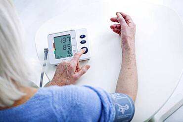 Senior woman measuring her blood pressure.