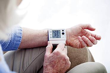 Senior woman measuring her blood pressure.