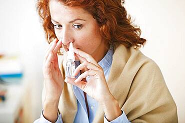 Woman using nose spray