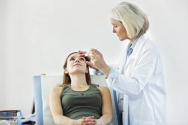 Woman using eye lotion