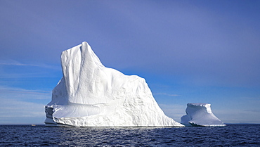 Iceberg off the coast of Newfoundland, Canada. With fishing boat at left for scale.