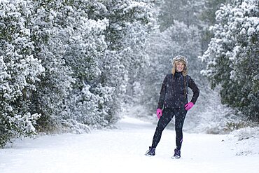 Caucasian young woman enjoying in snow outdoor in winter time. Navarre, Spain, Europe.