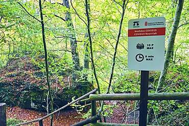 Signal with COVID 19 precautionary measures in a nature place. Urederra river source. Urbasa-Andia Natural Park. Navarre, Spain, Europe.