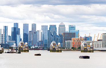 The River Thames Flood Barrier, one of the largest movable flood barriers in the world, with Canary Wharf in the background, London, England