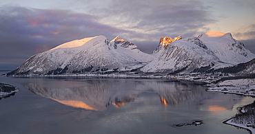 Dawn light over the village of Bergsbotn and Bergsfjord backed by the Bergsbotn mountain range in winter, Senja, Troms og Finnmark county, Norway, Scandinavia, Europe