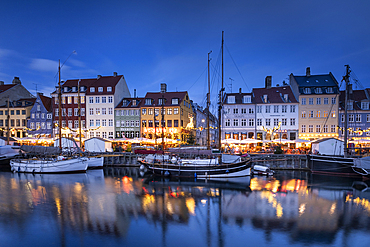 Colourful buildings and tall masted boats on the waterfront at Nyhavn at dusk, Nyhavn Canal, Nyhavn, Copenhagen, Denmark, Europe