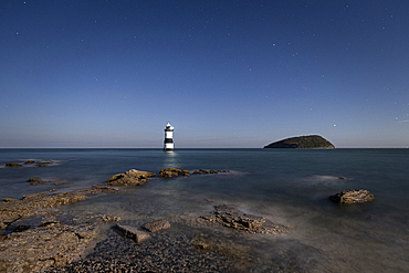 The night sky over Trwyn Du lighthouse, Penmon Point, Penmon, Isle of Anglesey, North Wales, UK